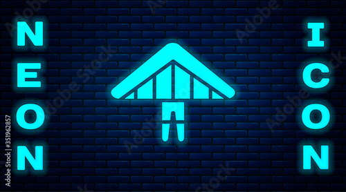 Glowing neon Hang glider icon isolated on brick wall background. Extreme sport. Vector
