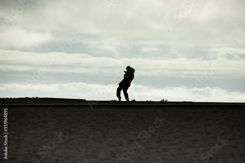 Silhouette of a young mother holding her child on the beach. A slow restart after confinement