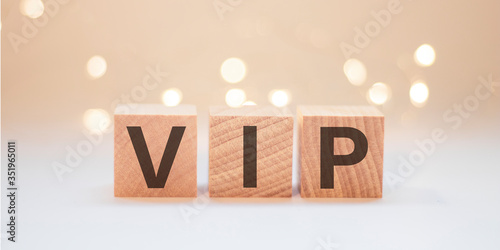 Wooden cubes with the word VIP on a background of lights.
