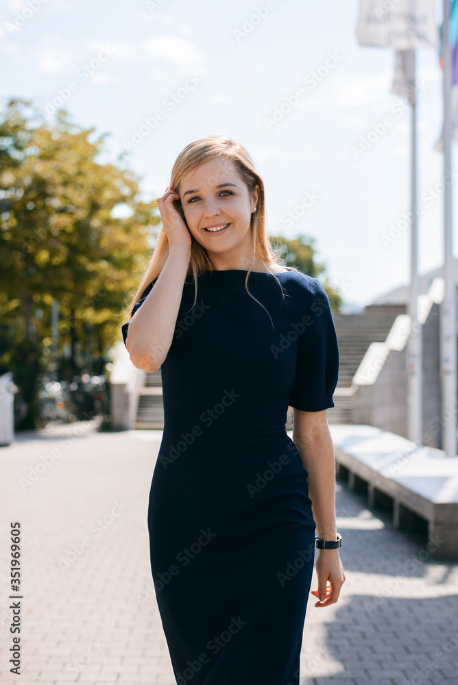 Young beautiful girl in black dress outdoor in the town