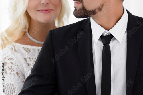 Woman hugs his man from behind. .Foreground man. Man in suit.