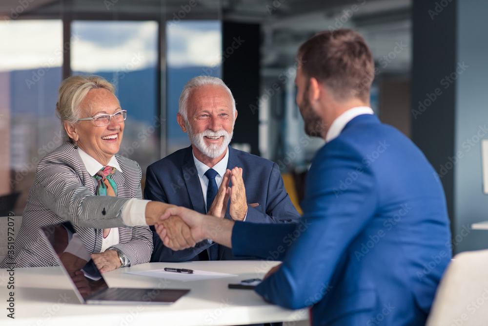 Fototapeta premium Positive aged couple consulting with insurance agent