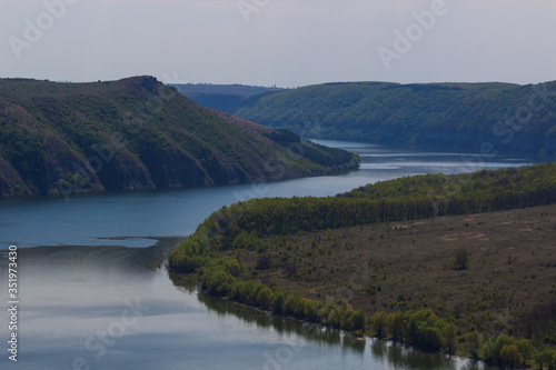 Zigzag river flows between summer valleys. Dniester river