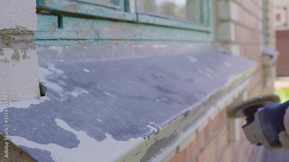 Paint and rust removing from metal plate, worker using wire brush at grinder power tool Paint and rust removing from metal plate, worker using wire brush at grinder power tool