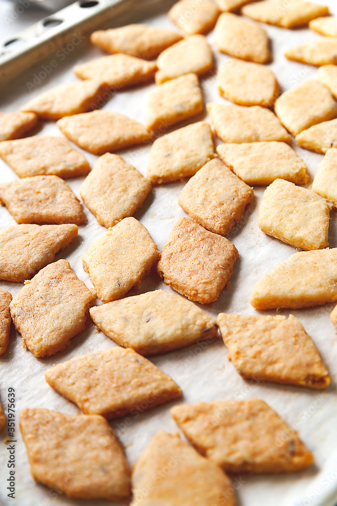 Homemade cookies. A lot of hot freshly baked cheese pastry on a baking sheet. Selective soft focus. Homemade cookies. A lot of hot freshly baked cheese pastry on a baking sheet. Selective soft focus.