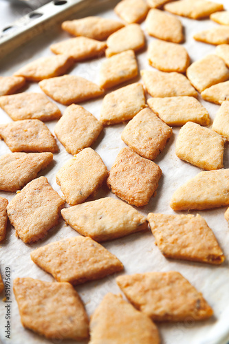 Homemade cookies. A lot of hot freshly baked cheese pastry on a baking sheet. Selective soft focus.