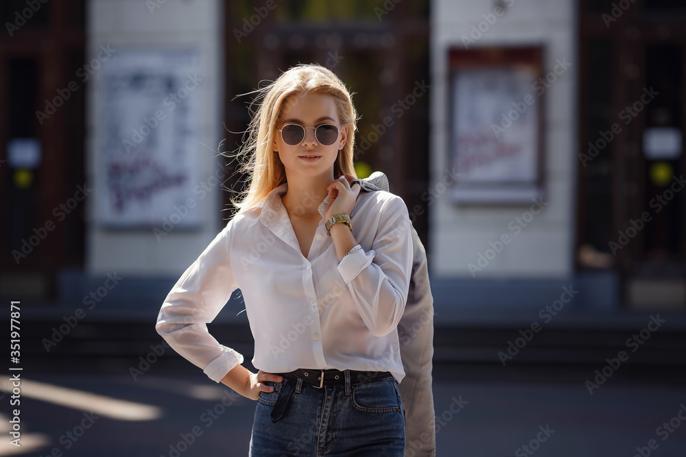 Sunny lifestyle fashion portrait of a young stylish hipster woman walking in the city, wearing a fashionable outfit Sunny lifestyle fashion portrait of a young stylish hipster woman walking in the city, wearing a fashionable outfit