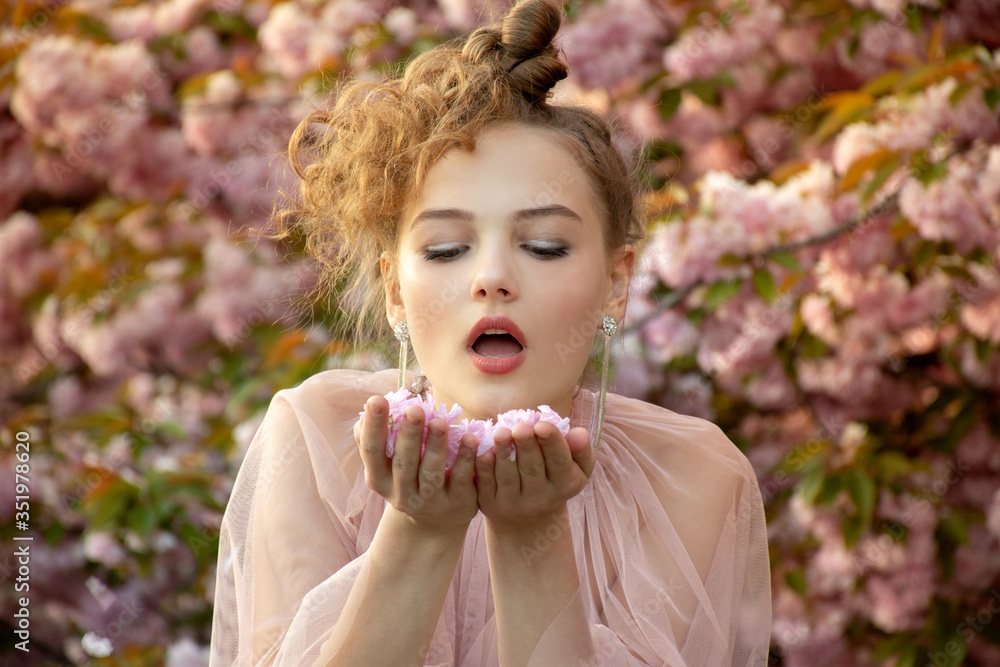 beautiful teenage girl who blows on fallen flowers of sakura tree Stock ...