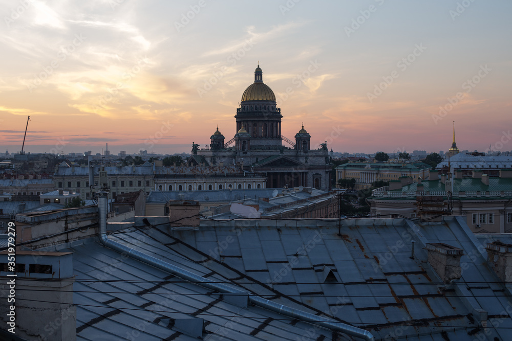 Sunset view at the Isaak Cathedral from the roof of Saint-petersburg city. Ancient roof of the city. Old historical city. Amazing sunset at the top of the city.