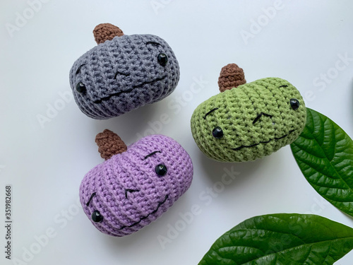 Cute pumpkins of different colors, crocheted on a white background. Handmade for autumn decoration. The day of Halloween and Thanksgiving