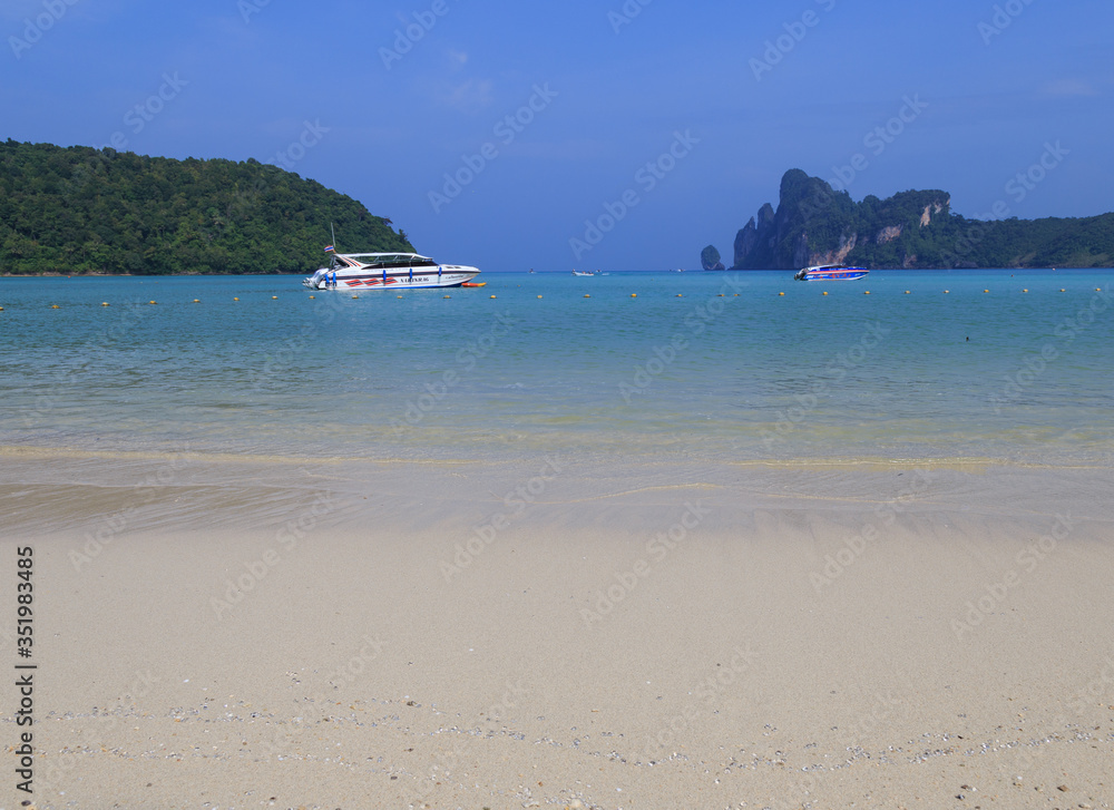 Holidays at the sea. Wonderful sea view surrounded by mountains. Blue water of the sea. Very relaxing vacation. Phi Phi island and boat. Cliffs and clear beaches on Phi Phi Island in Thailand.