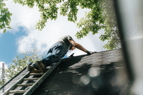 home owner climbing up rooftop on ladder