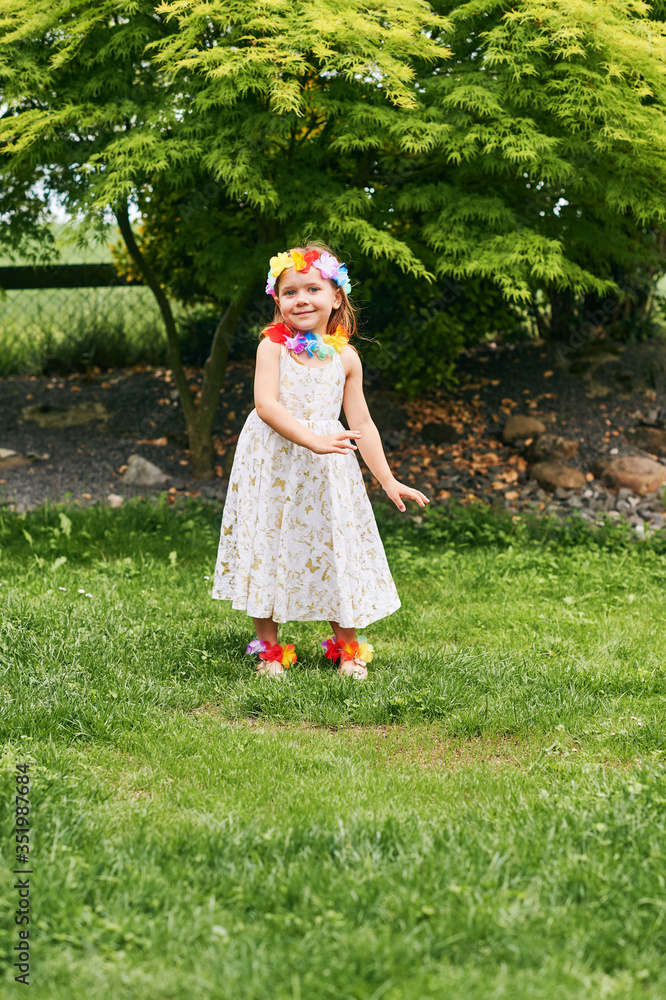 Outdoor portrait of adorable little girl playing in park, wearing white dress and colorful flowers Outdoor portrait of adorable little girl playing in park, wearing white dress and colorful flowers
