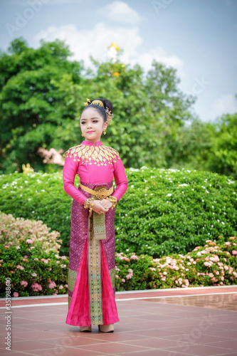 Portrait smiling Asia Girl in Thai Traditional Antique Dress of Old Kingdom in Siam, Southeast Asia.