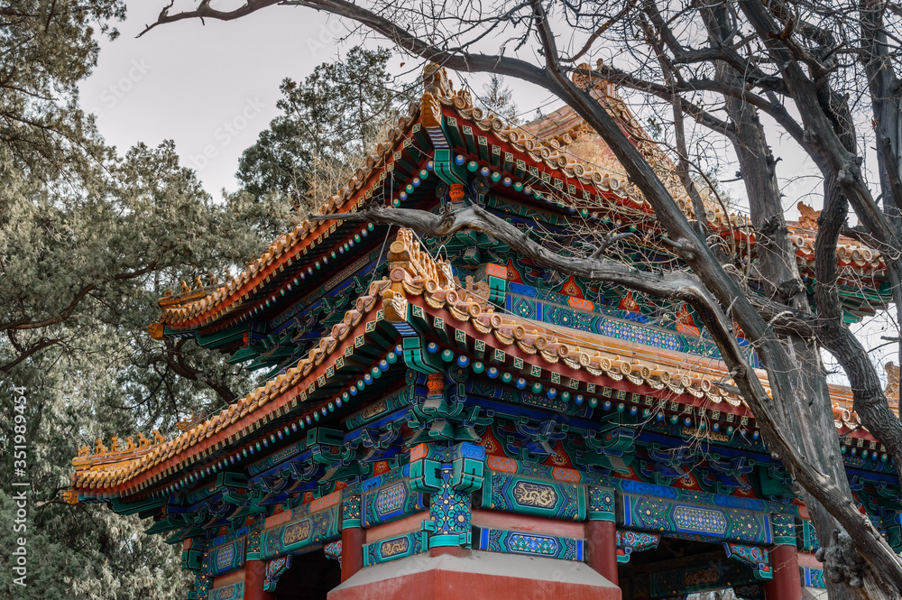 Richly decorated roofs of Chinese houses, numerous colorful paintings on the structure.