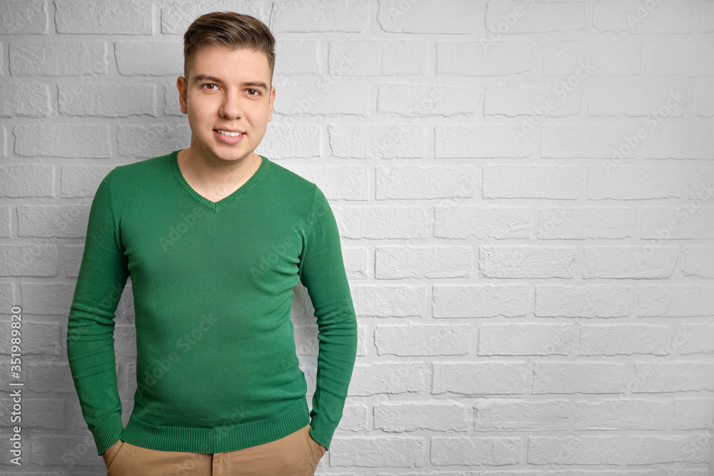 Portrait of a handsome caucasian man smiling. Brick wall background. Studio photo. There is a place to copy space. Portrait of a handsome caucasian man smiling. Brick wall background. Studio photo. There is a place to copy space.