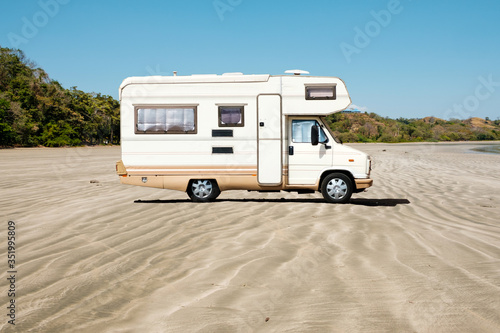 old camping bus, rv camper van at beach -