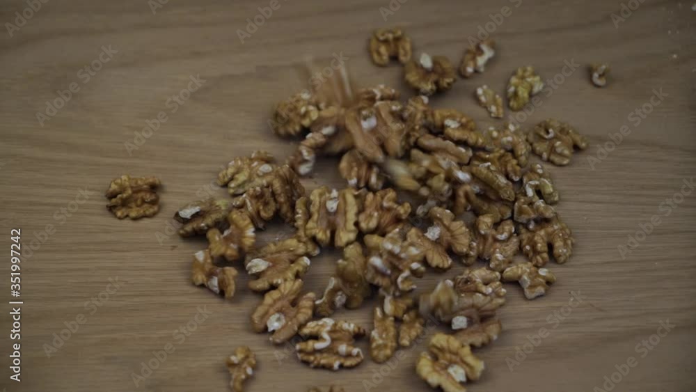 Organic Walnut kernel falling on wooden background. Slow motion. Organic Walnut kernel falling on wooden background. Slow motion.