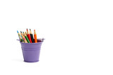 Multi-colored pencils in a purple bucket isolated on a white background, there is a place for text. Banner.