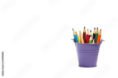 Multi-colored pencils in a purple bucket isolated on a white background, there is a place for text. Great for website banner.