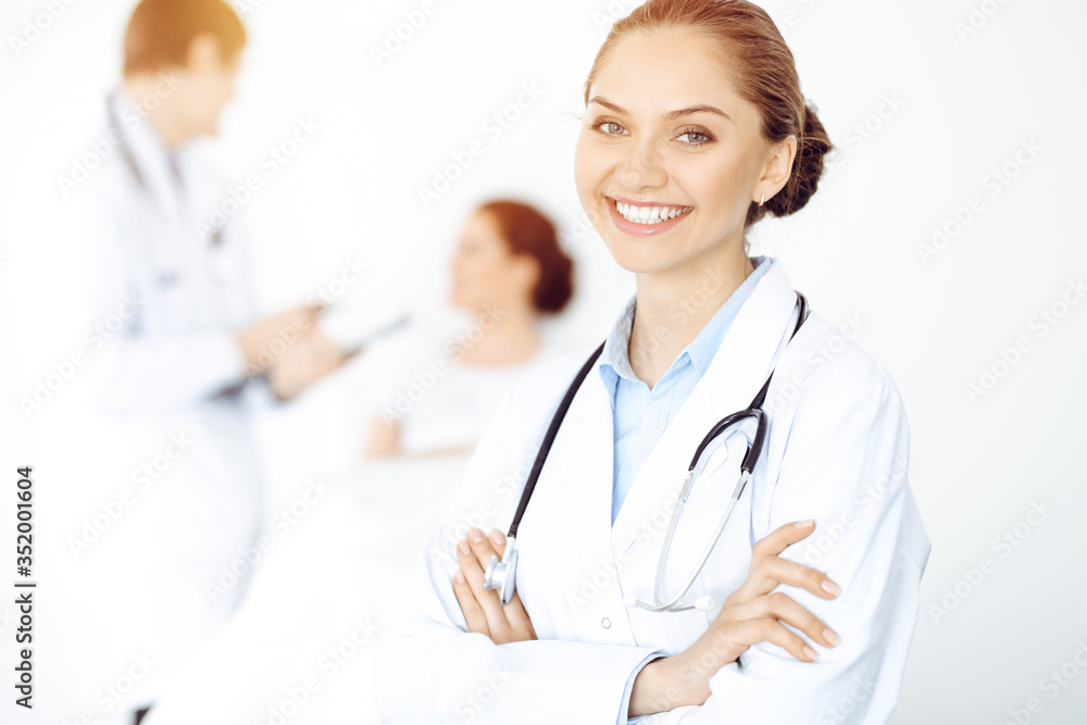 Cheerful smiling woman-doctor on the background of his patient in the bed. Medicine concept Cheerful smiling woman-doctor on the background of his patient in the bed. Medicine concept