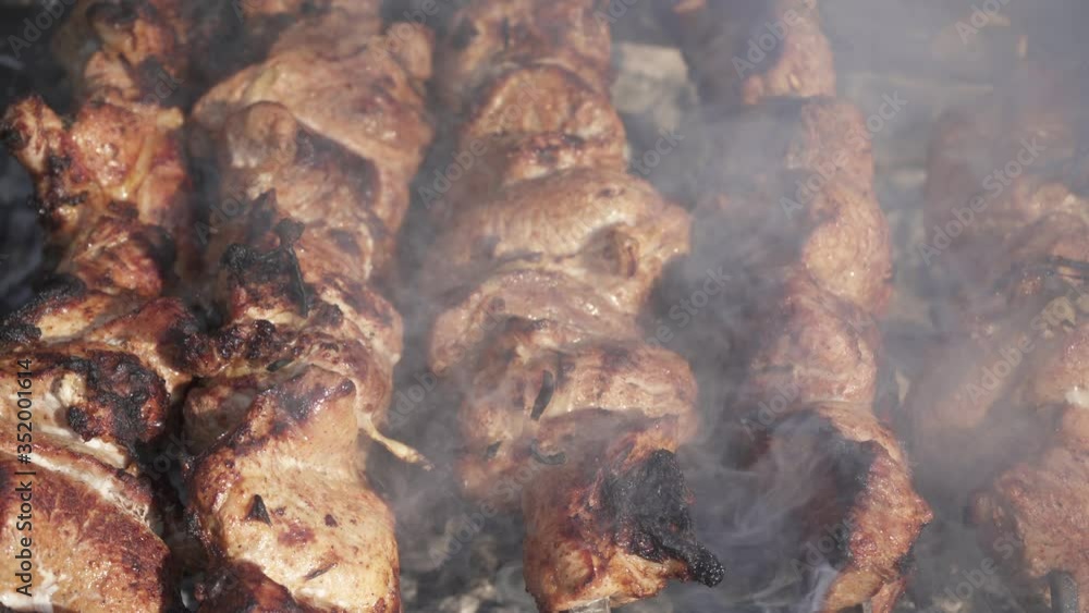 Grilling raw meat on outdoor grill with smoke. Grilling raw meat on outdoor grill with smoke.