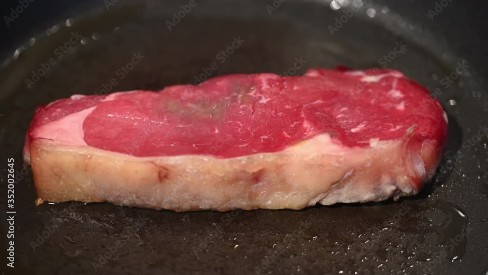 Shots of a sliced raw fresh rump steak with fat on the steak in a pan, which the steak cooks through in high heatc Shots of a sliced raw fresh rump steak with fat on the steak in a pan, which the steak cooks through in high heatc