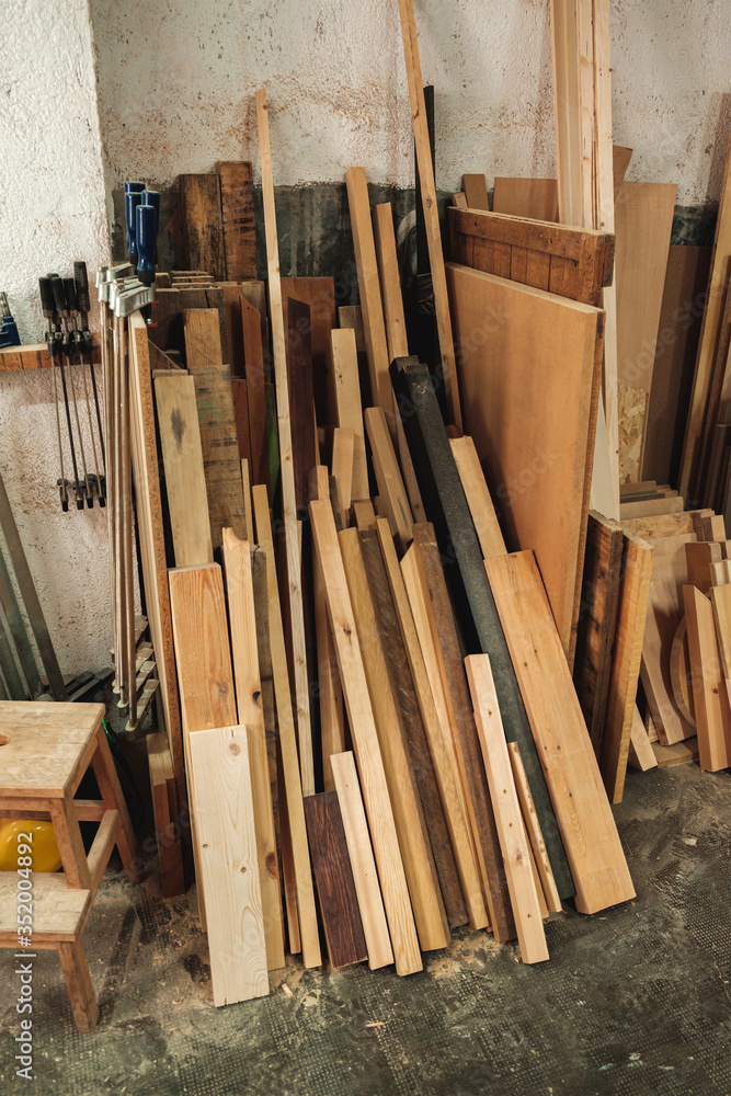 Chunks and pieces of wood leaning against the wall of a carpentry, a wood workshop Chunks and pieces of wood leaning against the wall of a carpentry, a wood workshop