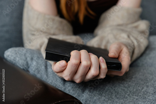 Close photo of women's hands with a black book, focus on fingers. photo