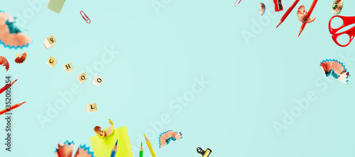 Creative back to school background with flying pencil shavings, wooden letter seals on a blue background with copy space. The letters are grouped into the word SCHOOL. Banner.