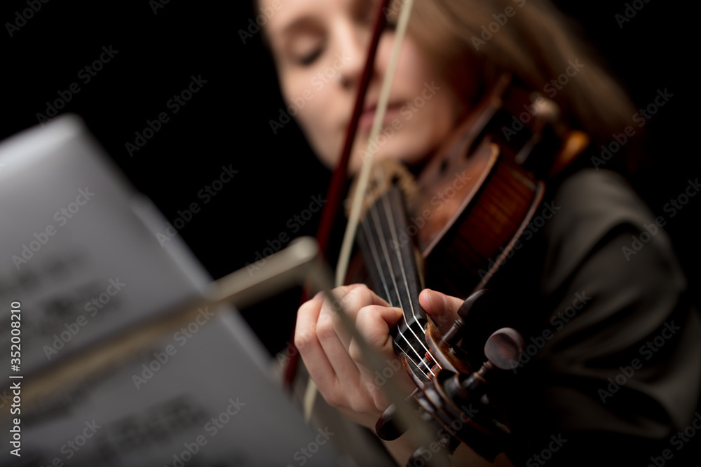 Woman playing a classical violin during a recital Woman playing a classical violin during a recital