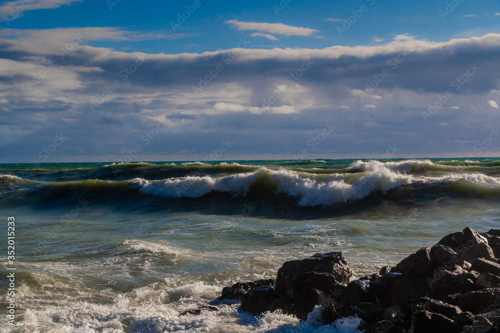 Storm and storm in the Black sea. Dark storm waves with a cap of foam beat against the rocks