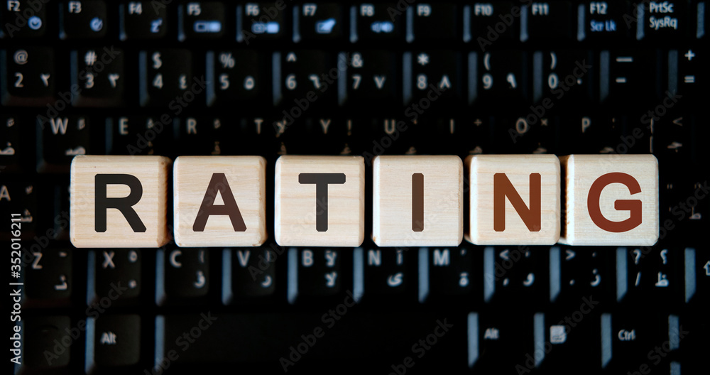 Rating - concept text on wooden cubes on background black keyboard Rating - concept text on wooden cubes on background black keyboard