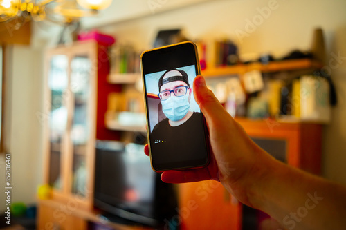 Young man is talking by video call in mask.