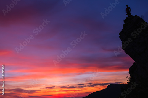Silhouette d   un photographe au sommet d   une montagne avec un magnifique coucher de soleil en arri  re plan 