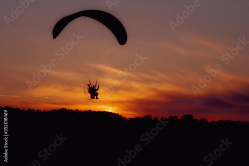 Paraglider flight at sunset