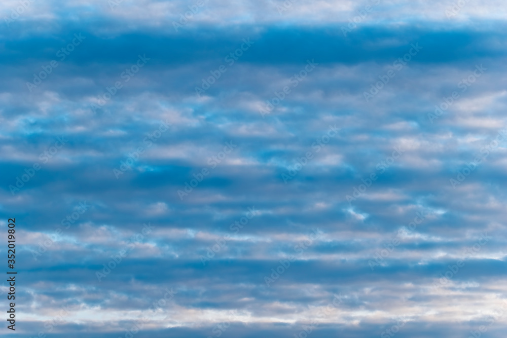 Fototapeta premium Clouds in the blue sky arranged in equal lines