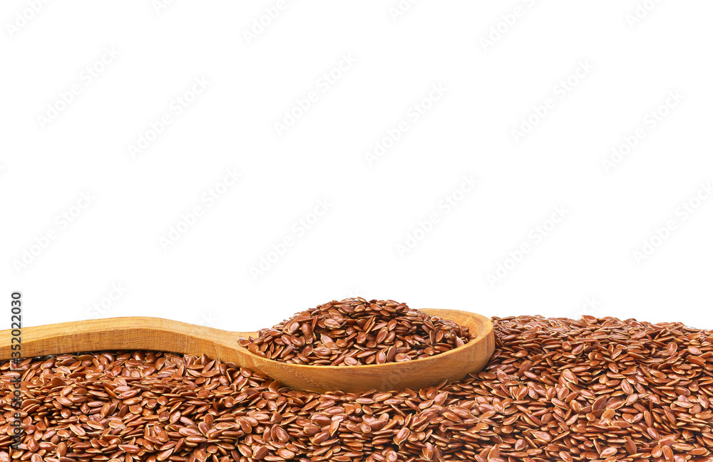 Flax seeds on a wooden spoon isolated with copy space for text. Flax seeds on a wooden spoon isolated with copy space for text.