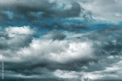 Dramatic multi-tones blue sky and fluffy white and gray clouds background.