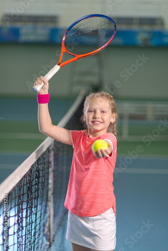A girl plays tennis on an indoor tennis court. © sheikoevgeniya