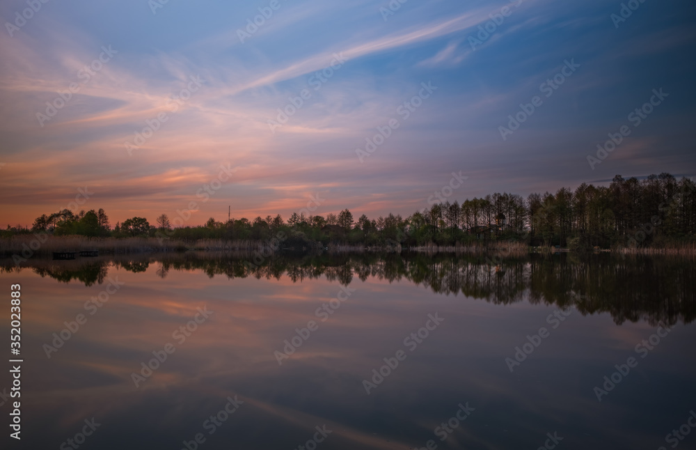 Sunset evening view on Sukhovilske Lake and forest in Sukhovolia, Rudno. Lviv district, Ukraine. May 2020