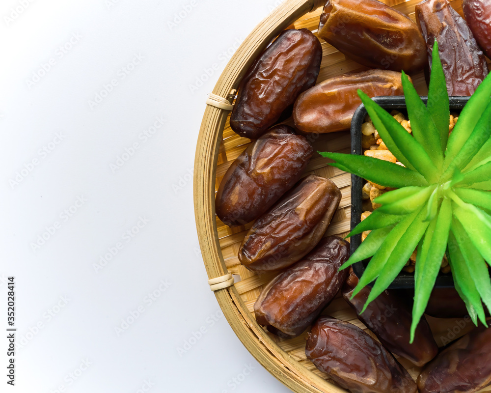 Dates or kurma on white background with flower pot, the favorite food of the holy ramadhan month. Dates or kurma on white background with flower pot, the favorite food of the holy ramadhan month.