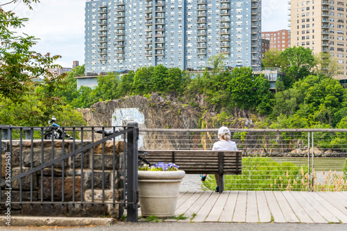 Elderly Woman Sits On A Park Bench And Enjoys The Views Of Inwood Hill Park.