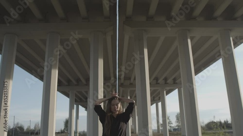 A girl stands under the bridge at sunrise