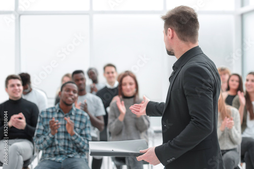 speaker and a group of diverse young listeners in a conference room