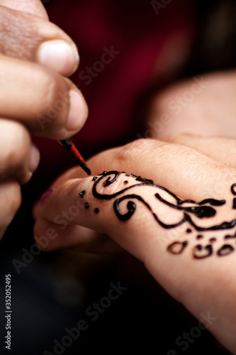 A woman doing a tattoo made of henna 