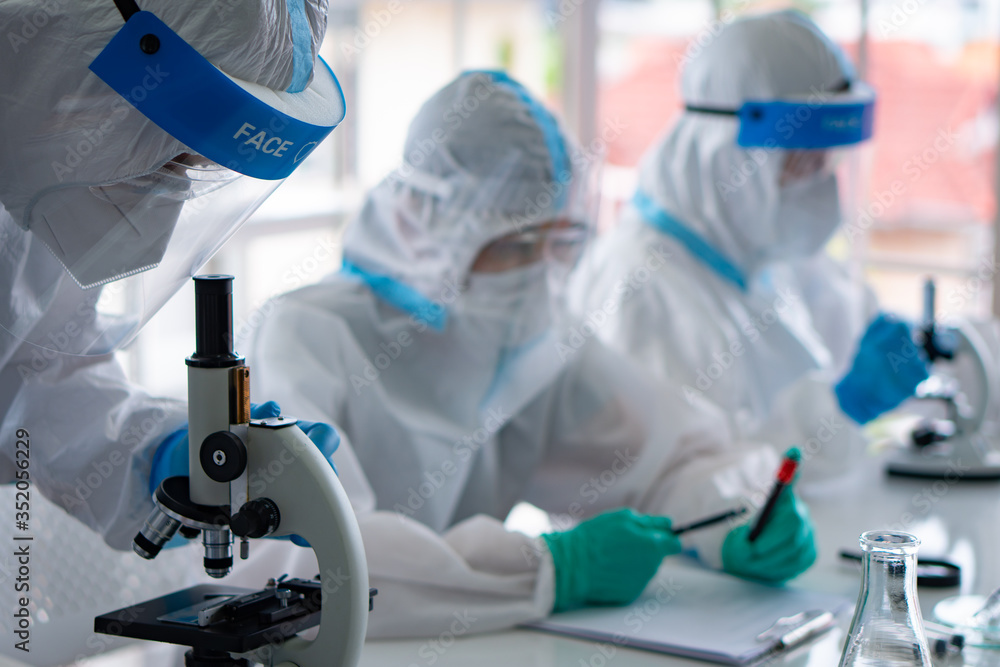 scientists in personal protective equipment or ppe doing research and experiment to find drugs to treat covid-19 or coronavirus infection in the lab scientists in personal protective equipment or ppe doing research and experiment to find drugs to treat covid-19 or coronavirus infection in the lab
