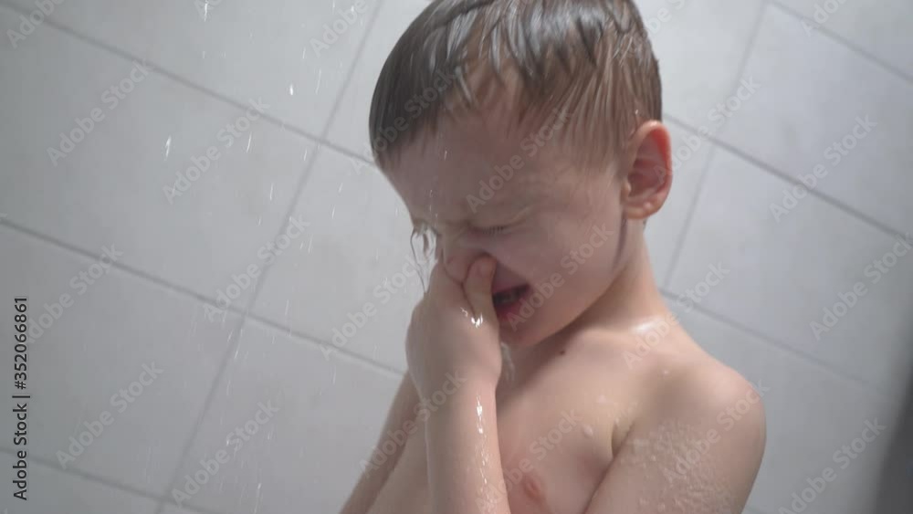 6-7 years old boy taking a bath, washes in the shower and smiles joyfully 6-7 years old boy taking a bath, washes in the shower and smiles joyfully