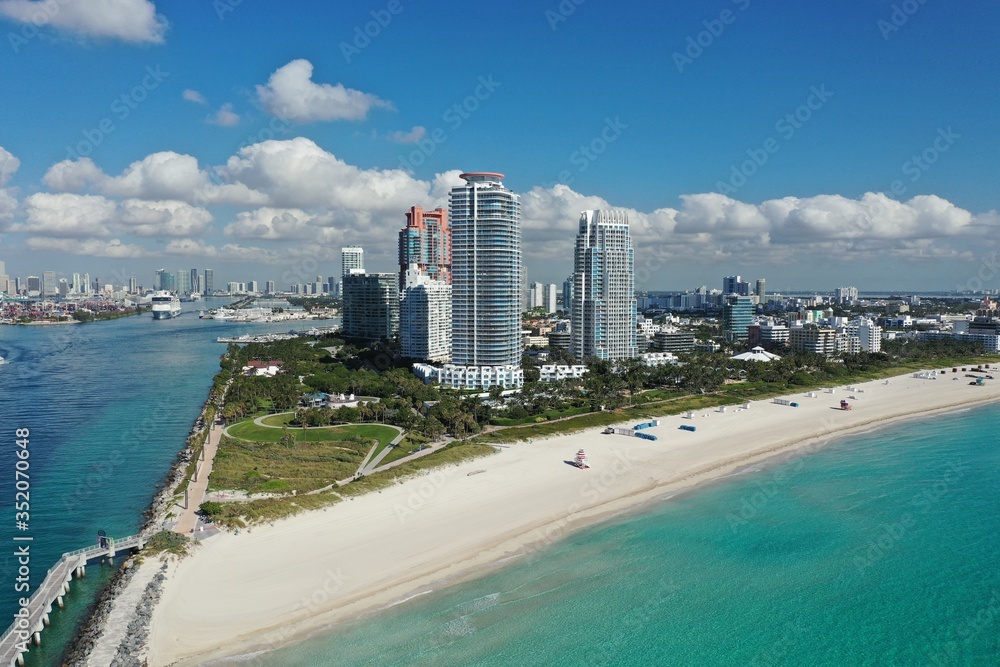Aerial view of South Pointe Park and South Beach in Miami Beach, Florida with Port Miami and City of Miami skyline in background.