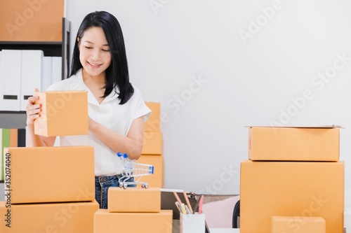 Asian beautiful empower woman working with online business shop at home.Owner businesswoman start up with Accept orders,Check number of products,Prepare to deliver products to customers.